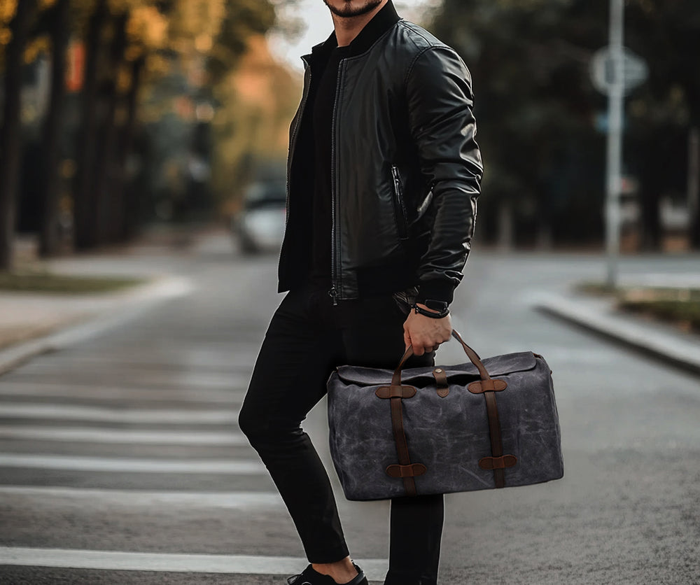 Stylish man holding a Sahara gym duffle bag while walking on a city street, showcasing fashion and functionality.