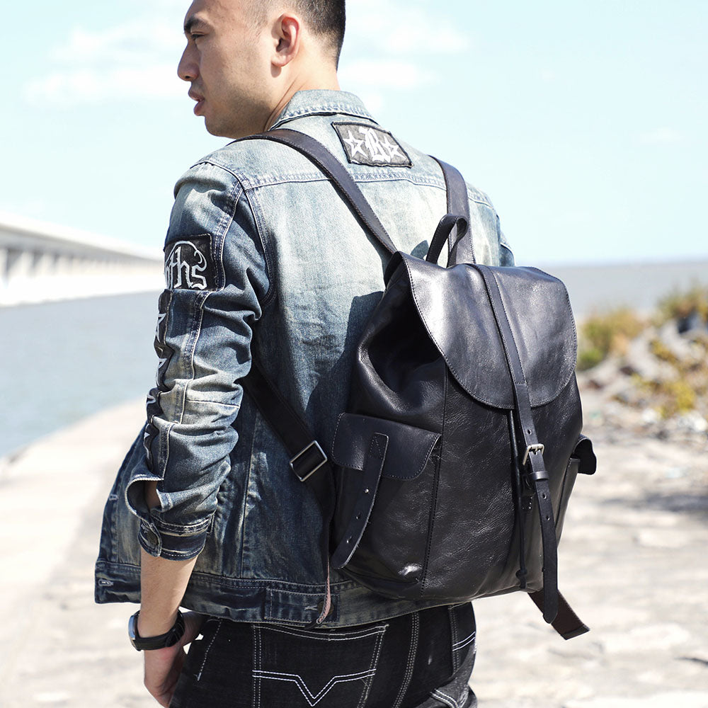 Man wearing a small black leather backpack, ideal for casual outings by Lake Victoria.