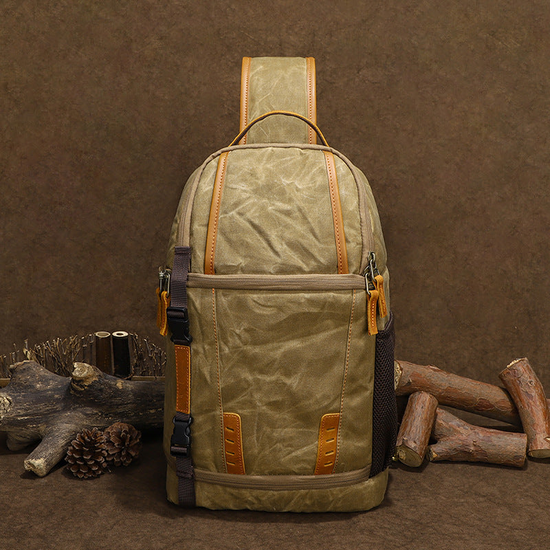 Canvas camera sling bag in olive green with tan accents, perfect for outdoor adventures and travel photography.