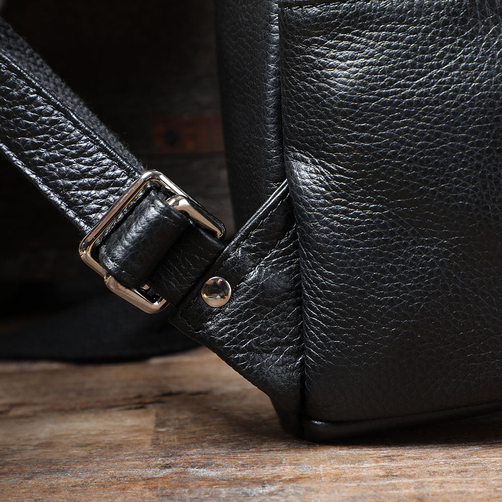 Close-up of the buckle and strap on a black leather bookbag from Death Valley, showcasing quality craftsmanship.
