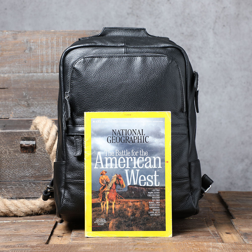Black leather bookbag displayed with National Geographic magazine about the American West.