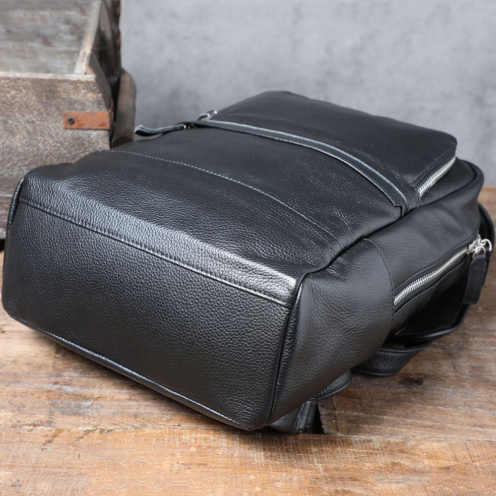 Black leather bookbag from Death Valley, featuring sleek design and durable material on rustic wooden surface.