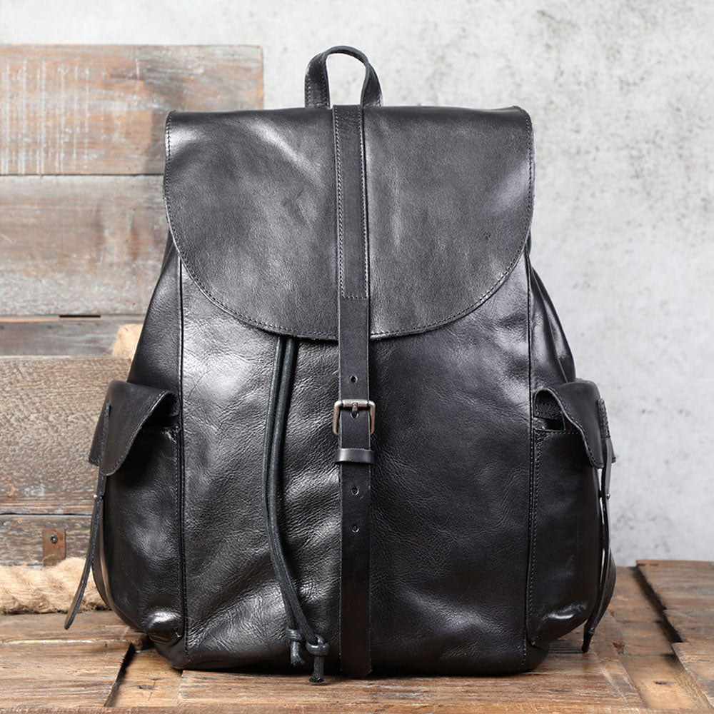 Small black leather backpack with pockets and drawstring closure, perfect for casual outings.