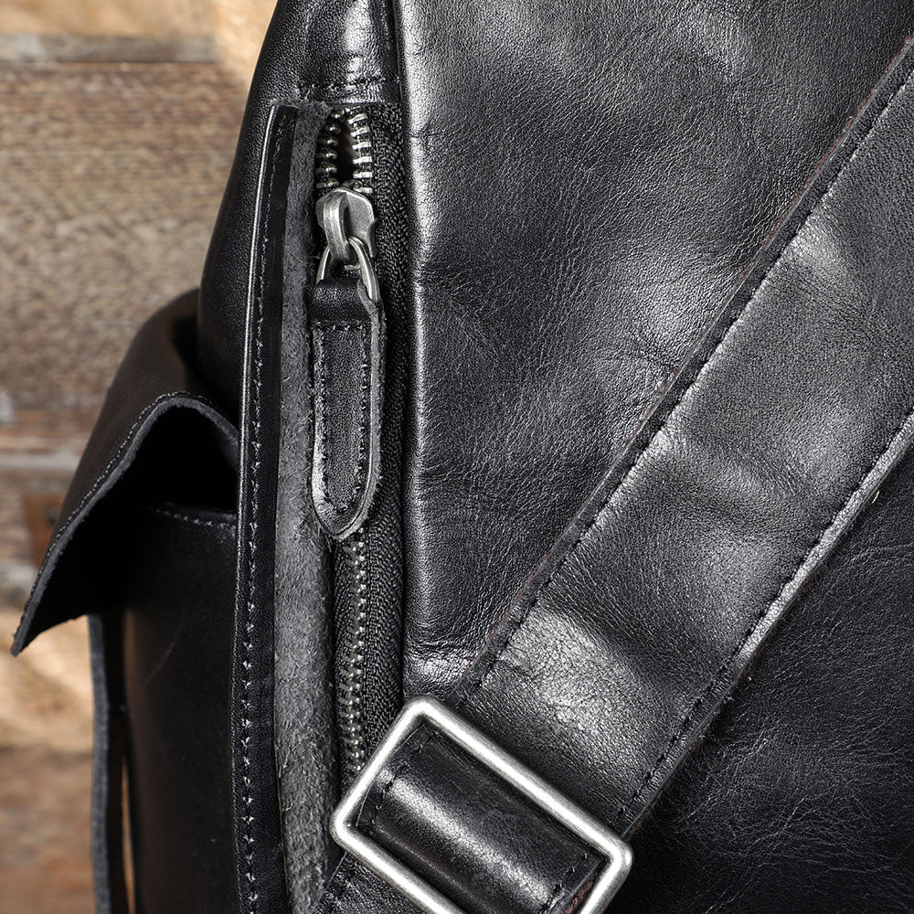 Close-up of a zipper on a small black leather backpack, showcasing quality craftsmanship and stylish design.