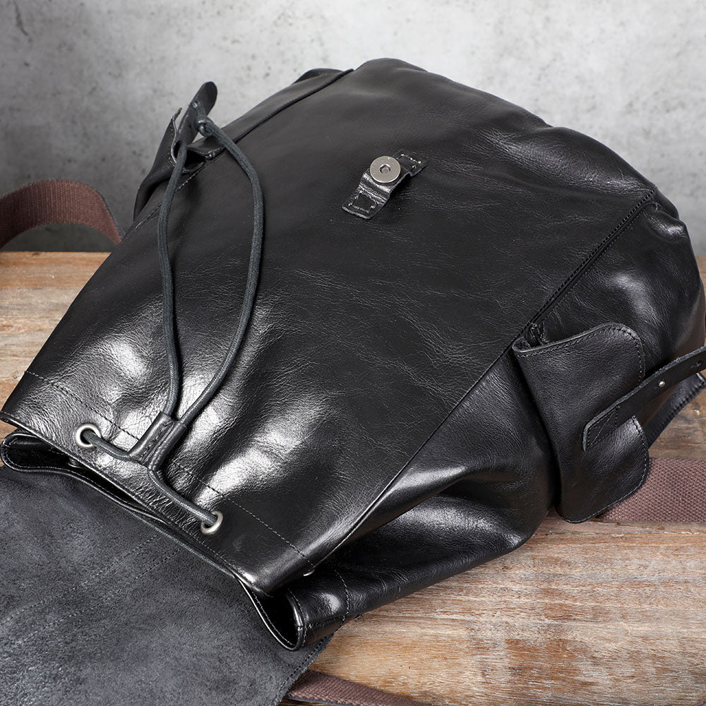 Small black leather backpack featuring a sleek design and drawstring closure, ideal for stylish outings.
