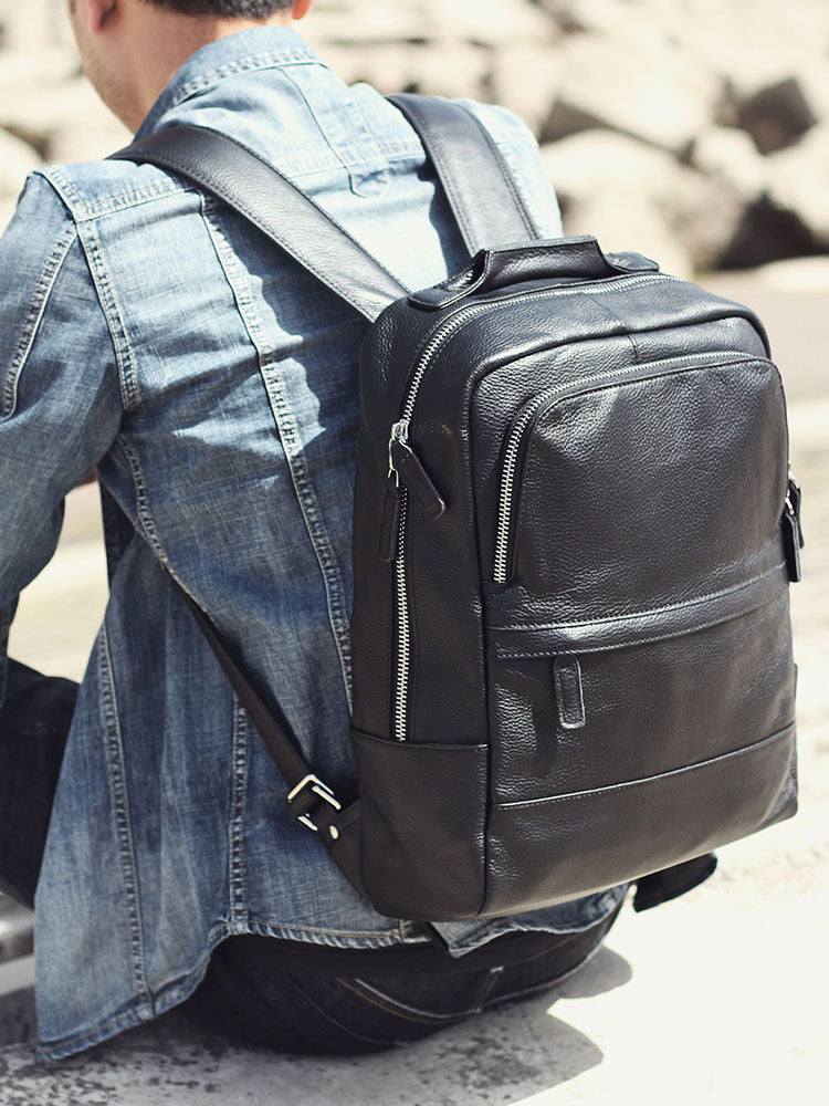 Stylish black leather bookbag being worn with a denim jacket, perfect for outdoor adventures.