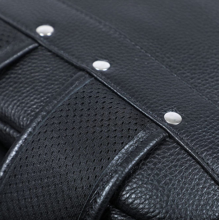 Close-up of black leather bookbag straps and hardware, showcasing quality craftsmanship and durability.