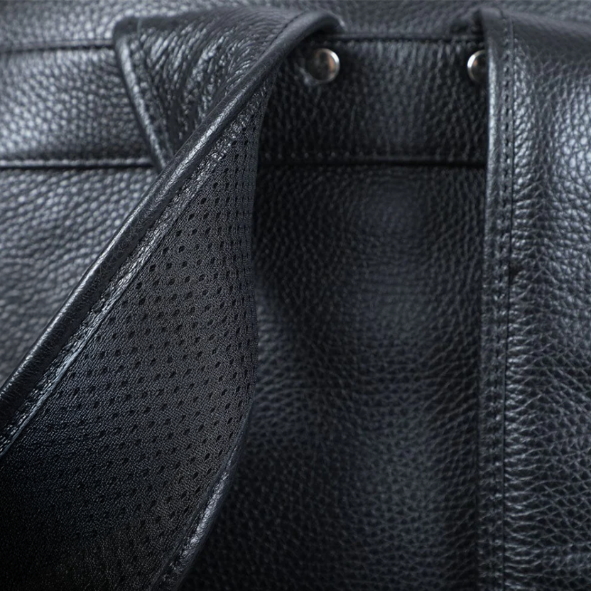 Close-up of black leather bookbag with detailed texture and straps, perfect for stylish and practical use.