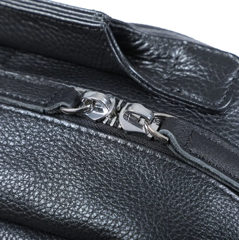 Close-up of the zipper on a black leather bookbag from Death Valley, showcasing its premium craftsmanship and design.