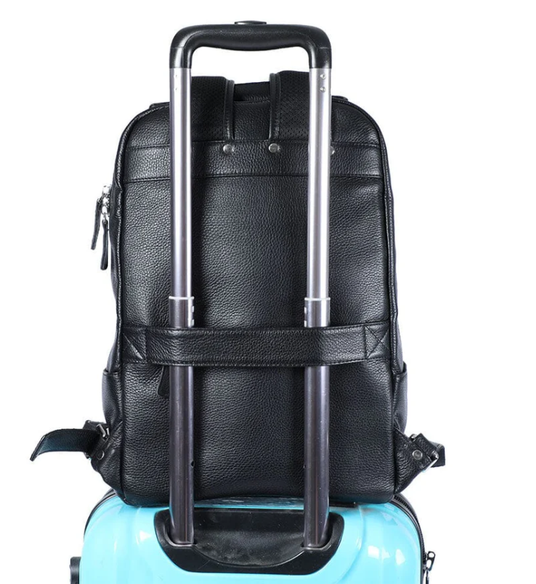 Black leather bookbag attached to a blue suitcase, showcasing its stylish and functional design for travel.