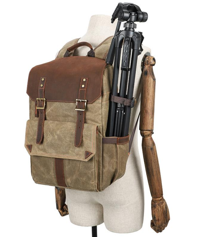 Stylish camera backpack with tripod holder, featuring brown leather accents and a rugged design, showcased on a mannequin.