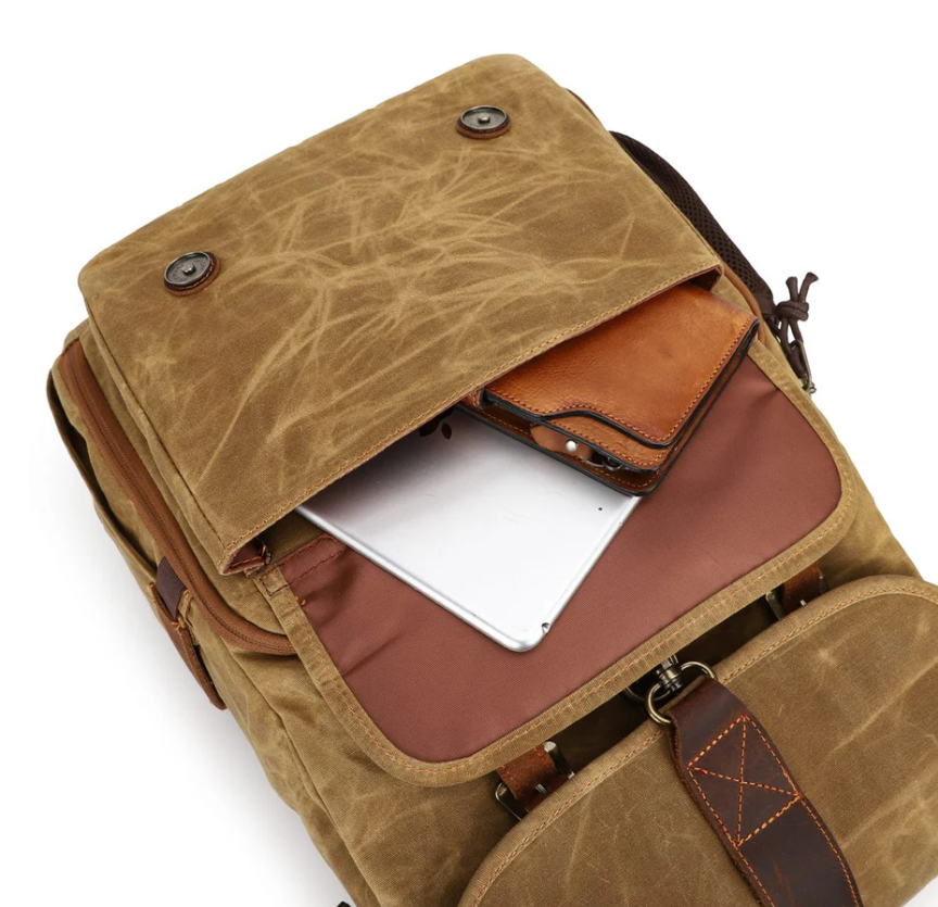 Canvas camera backpack by Kruger featuring a spacious top pocket with a laptop and leather wallet.