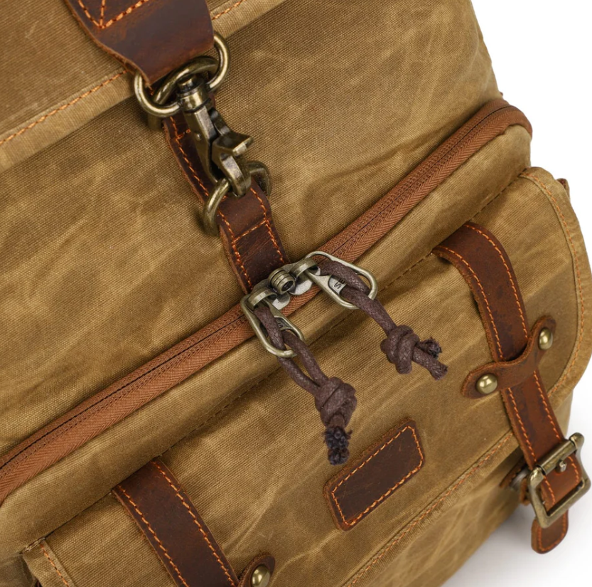 Close-up of the Kruger canvas camera backpack showcasing its sturdy buckle and leather accents.