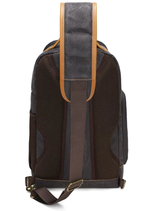 Back view of the Canvas Camera Sling Bag featuring mesh panels and leather straps, ideal for photographers.