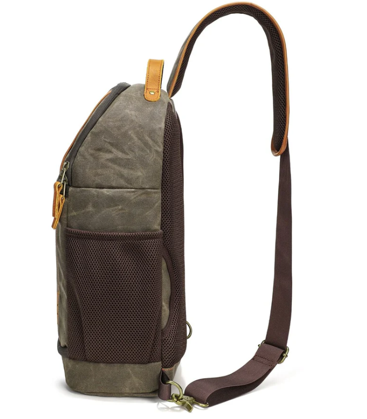 Canvas camera sling bag in olive green with leather accents and mesh side pocket, perfect for outdoor adventures.