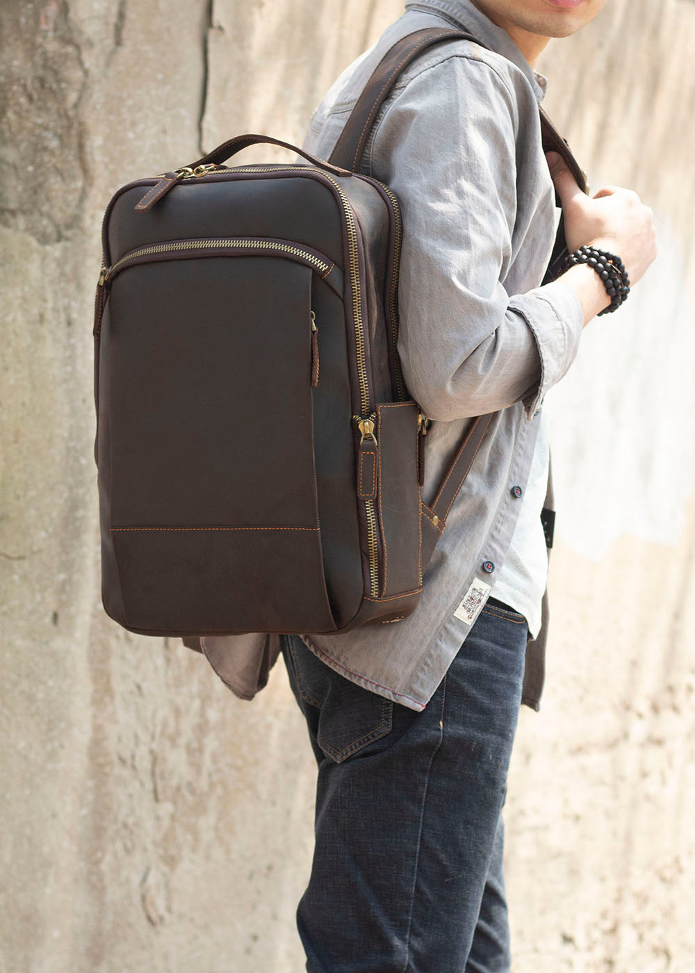 Leather laptop rucksack Loch Ness carried by a man, showcasing stylish and functional design in urban setting.