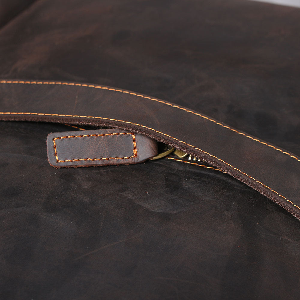 Close-up of the zipper and leather strap on the Loch Ness leather laptop rucksack, showcasing quality craftsmanship.