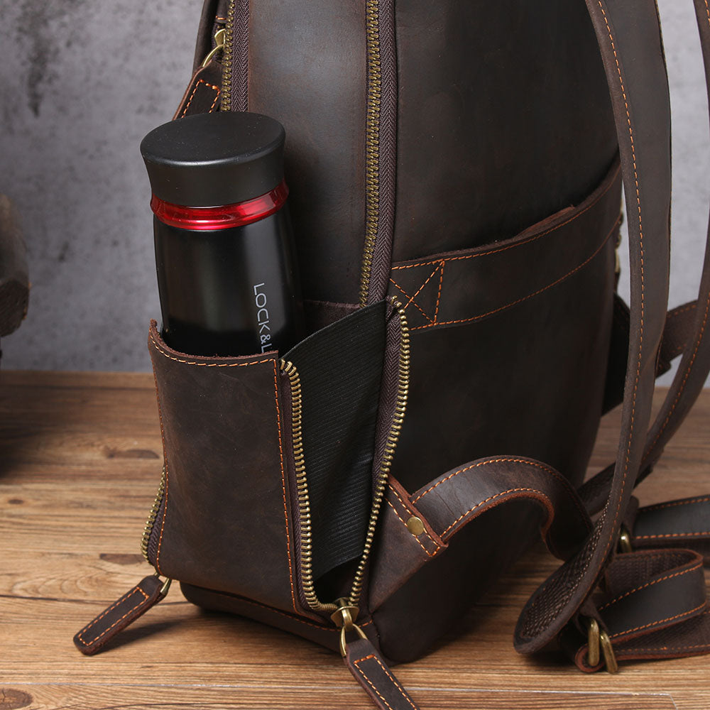 Leather laptop rucksack showing side pocket with a water bottle, highlighting practicality and style in dark brown leather.