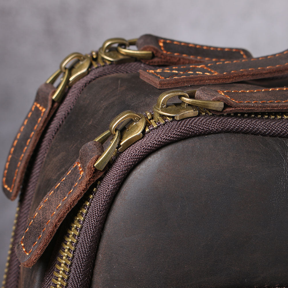 Close-up of the brass zippers and leather straps on the Loch Ness leather laptop rucksack.