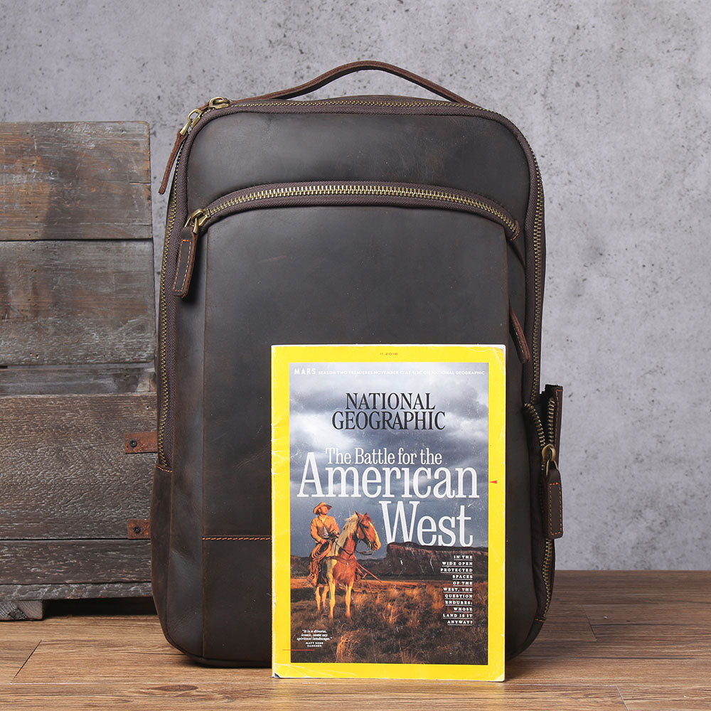 Leather Laptop Rucksack Loch Ness displayed with National Geographic magazine on a rustic wooden background.