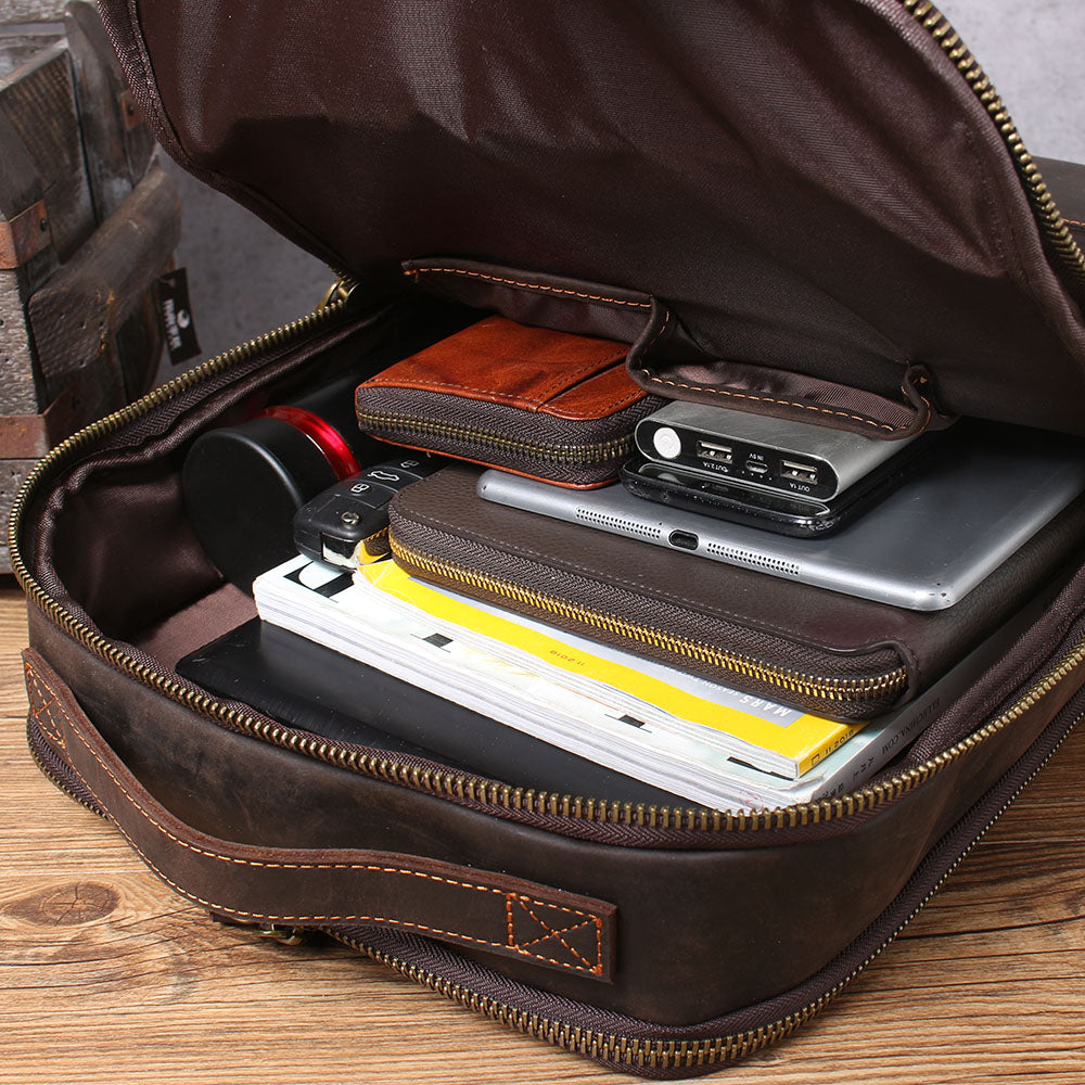Inside view of the Leather Laptop Rucksack by Loch Ness, showcasing organized tech gear and notebooks.