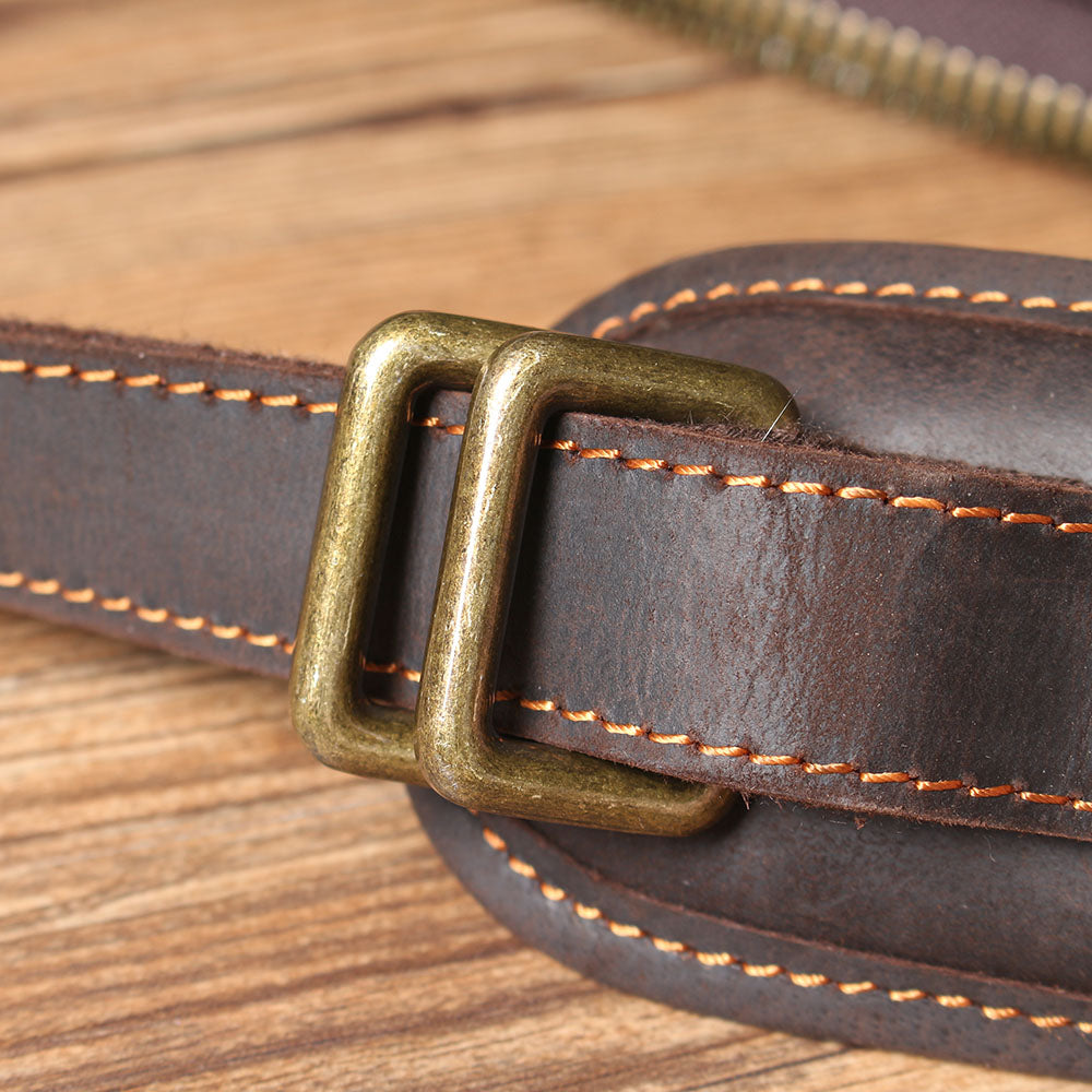 Close-up of the brass buckle on a leather laptop rucksack, highlighting quality craftsmanship and durable materials.
