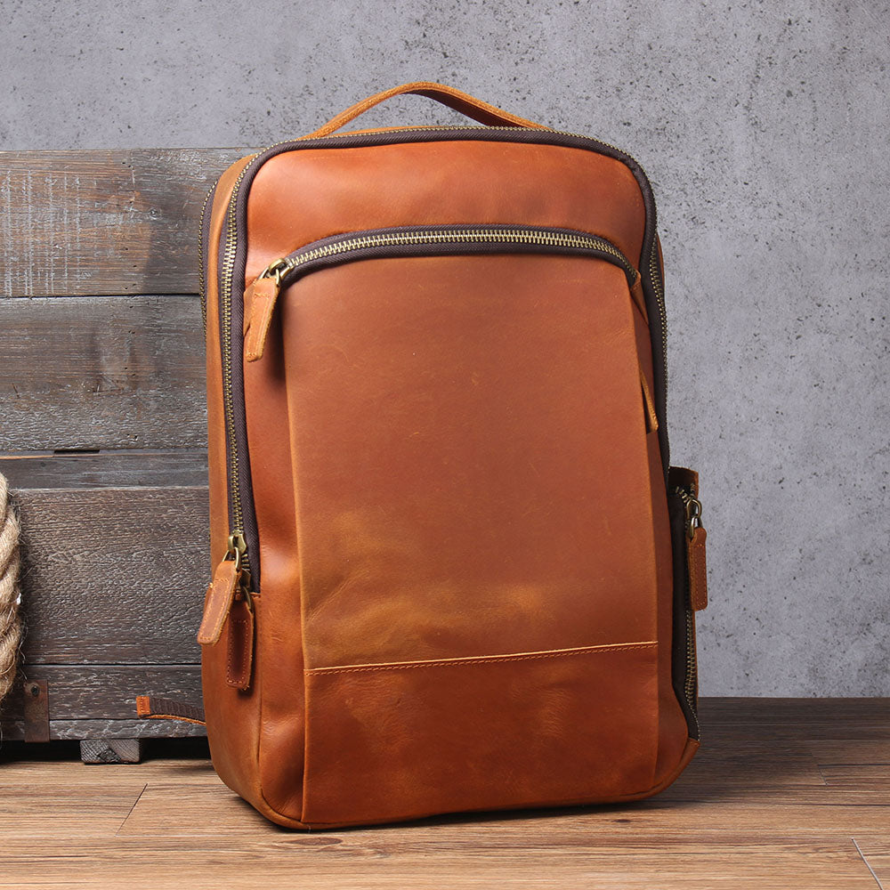 Brown leather laptop rucksack with multiple pockets and sturdy zipper, perfect for travel or daily use.