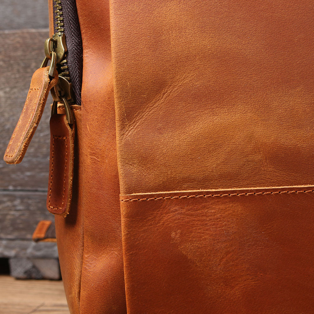 Close-up of the rich, brown leather texture and zipper detail of the Loch Ness Leather Laptop Rucksack.