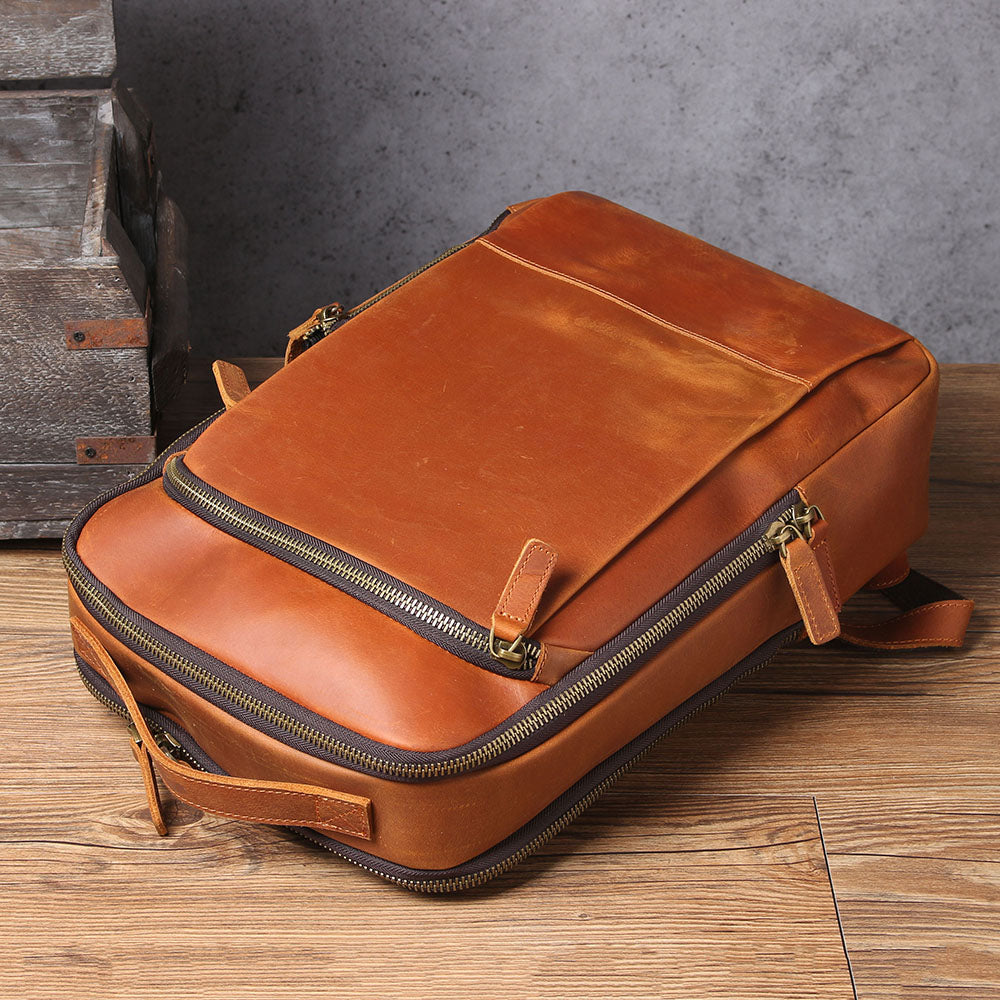 Elegant leather laptop rucksack in tan, featuring zippers and a spacious design for modern professionals.