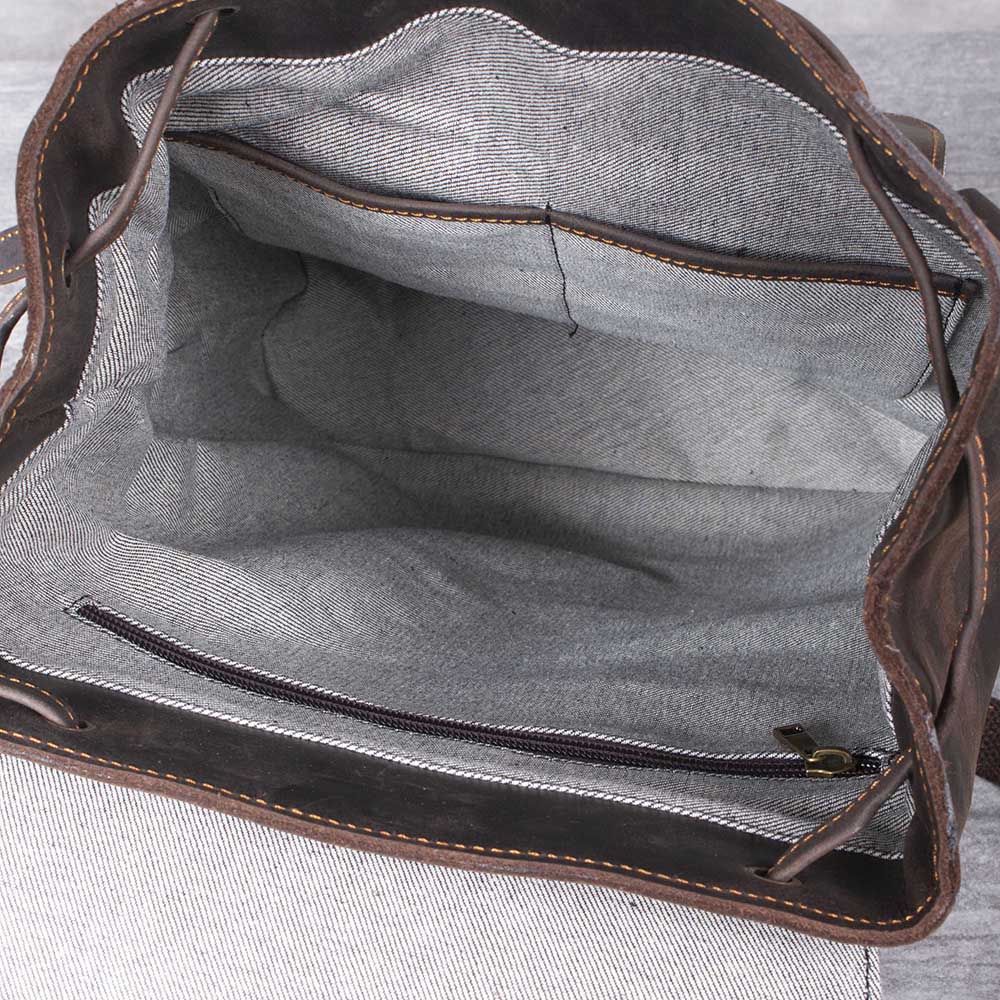 Interior view of a Leather Drawstring Backpack in Black Sea, featuring spacious compartments and a zippered pocket.