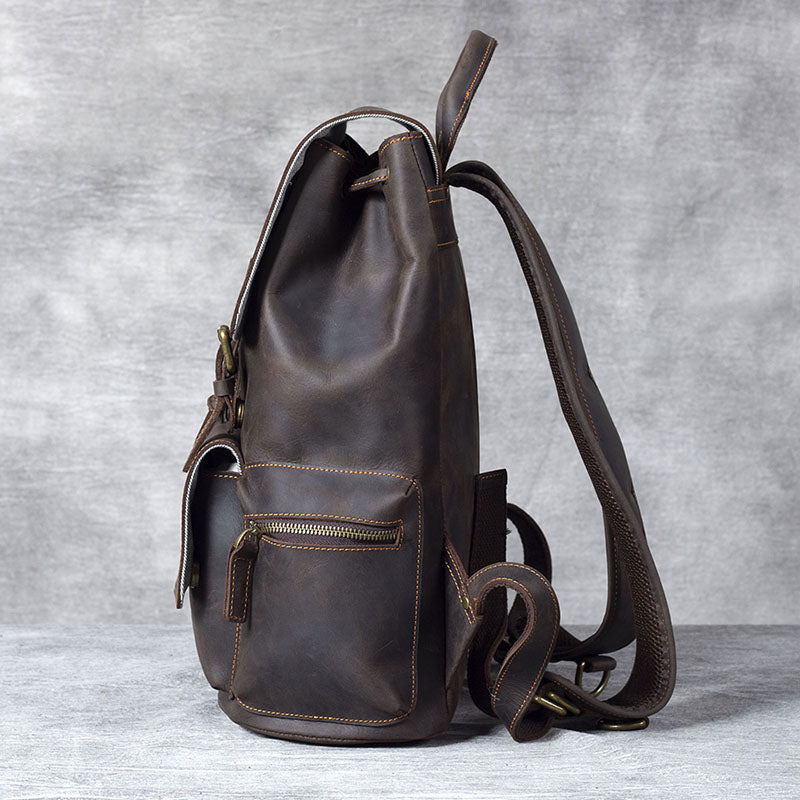 Black leather drawstring backpack showcasing side view and pockets, perfect for stylish storage and travel.
