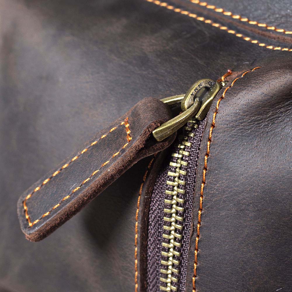 Close-up of the zipper detail on a rugged leather drawstring backpack crafted with quality materials.