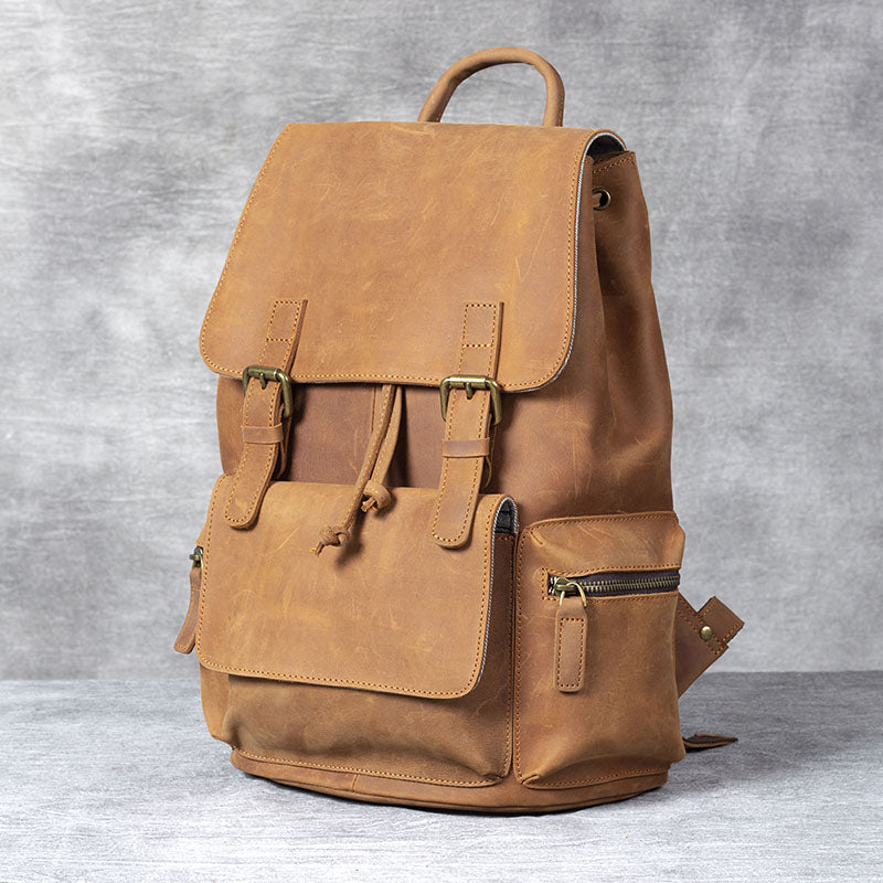 Stylish tan leather drawstring backpack with front pocket and adjustable straps, perfect for everyday use.