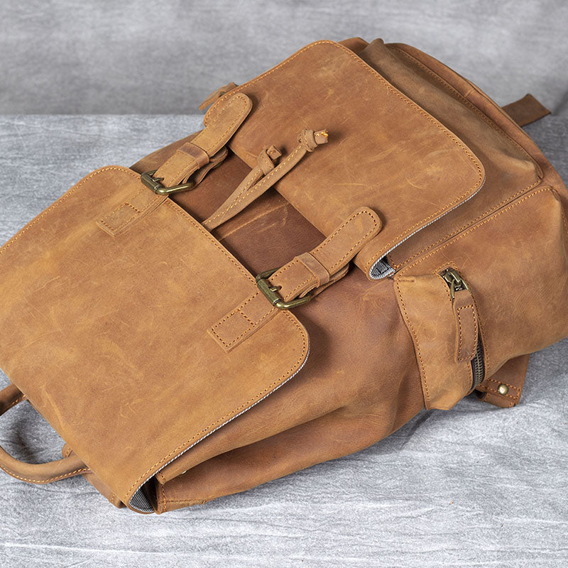 Spacious brown leather drawstring backpack, featuring multiple straps and pockets for versatile carrying.