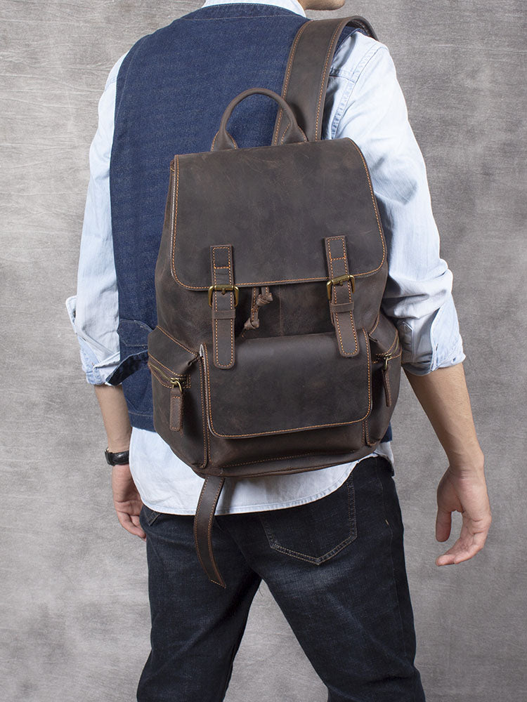 Man wearing a stylish leather drawstring backpack in dark brown against a textured background.