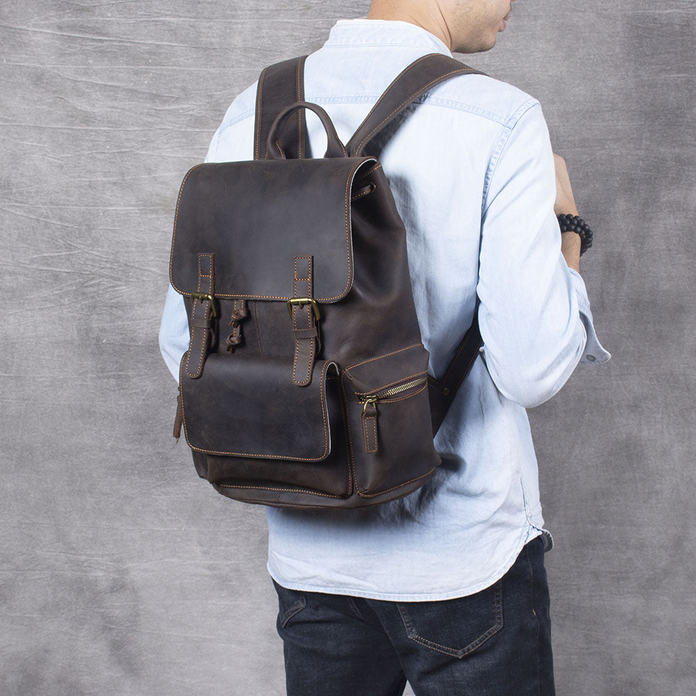 Black leather drawstring backpack worn on a person’s back, ideal for stylish travel and everyday use.