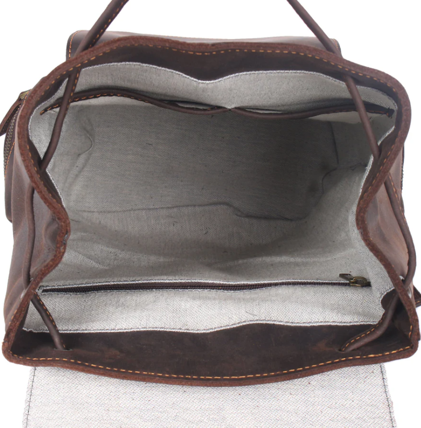 Interior view of a leather drawstring backpack, showcasing spacious compartments and a zippered pocket.