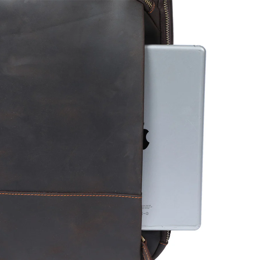 Leather laptop rucksack Loch Ness with laptop partially inserted, showcasing premium craftsmanship.