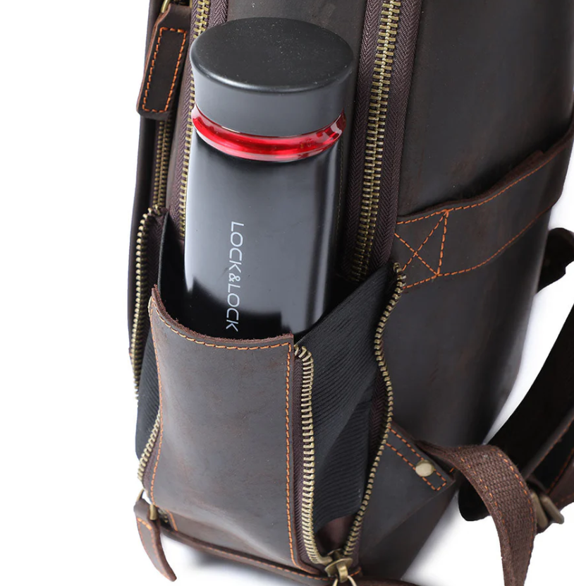Close-up of a leather laptop rucksack pocket with a black insulated water bottle inside.