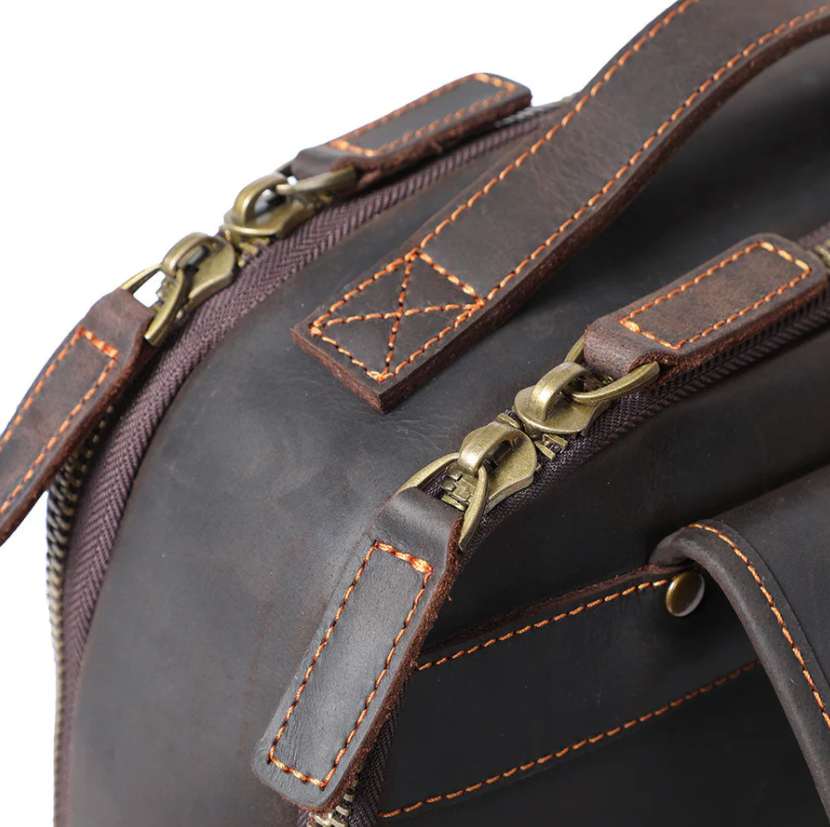 Close-up of the durable leather zippers on the Loch Ness leather laptop rucksack, showcasing quality craftsmanship.