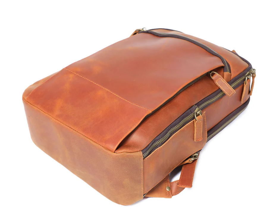 Leather laptop rucksack in rich brown with multiple zippers and adjustable straps, ideal for stylish travel.