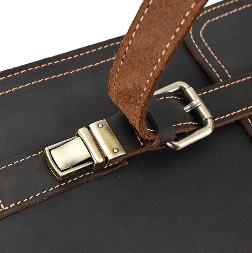 Close-up of the brass buckle and leather strap on a stylish black leather rucksack from Smokies.