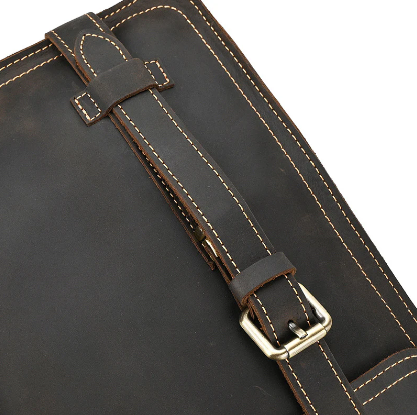 Close-up of the leather rucksack strap detailing, showcasing high-quality craftsmanship and sturdy buckle.