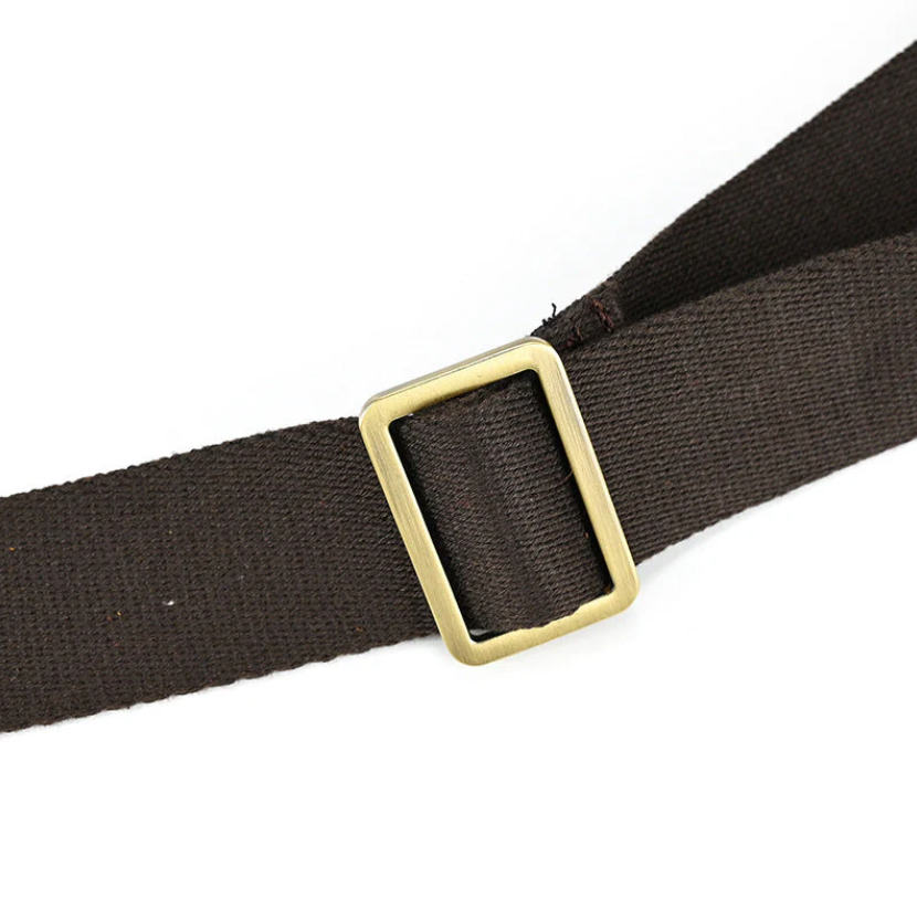 Close-up of a brown strap with a brass buckle for a leather rucksack, showcasing quality craftsmanship and design.
