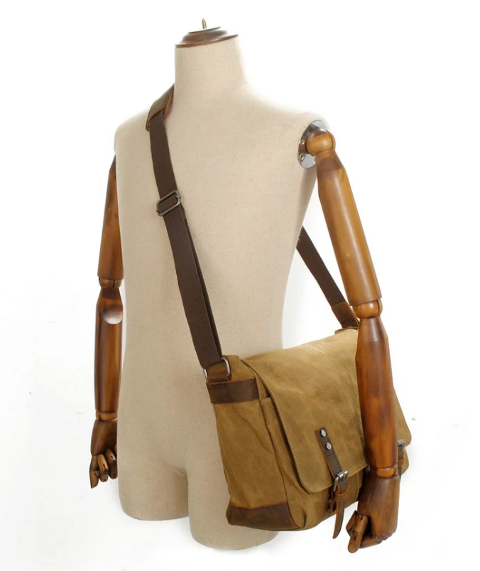 Retro shoulder bag with adjustable strap showcased on a mannequin, featuring a stylish brown canvas design.