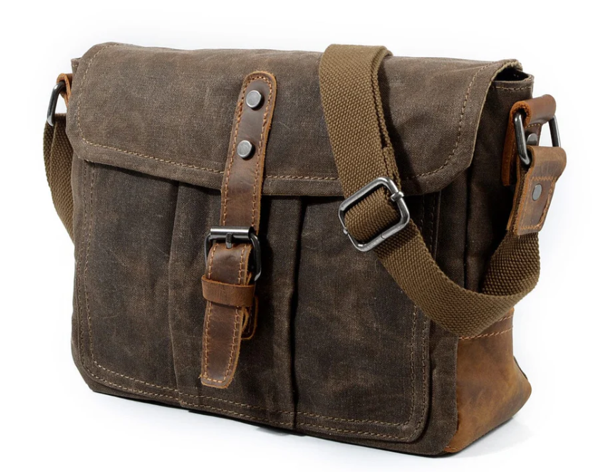 Small canvas messenger bag in brown with adjustable strap and buckle closure, perfect for everyday use.