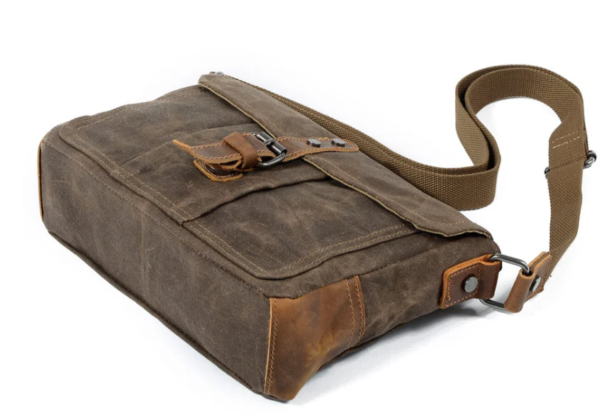 Small canvas messenger bag with leather accents and adjustable strap, perfect for everyday use.