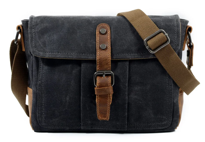 Small canvas messenger bag with brown leather accents and adjustable strap, perfect for everyday use.