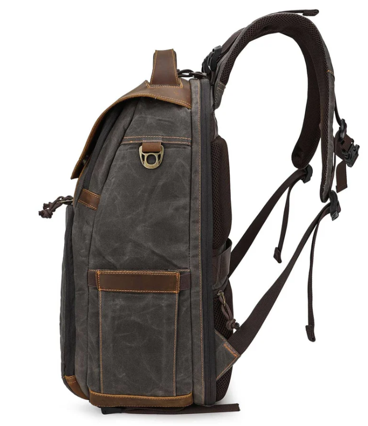 Vintage camera backpack in dark grey with leather accents, side view showcasing pockets and adjustable straps.