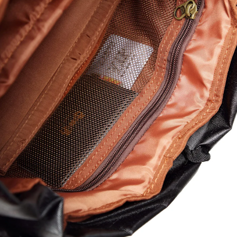 Interior view of waterproof canvas camera backpack showing organizational pockets and zipper details.